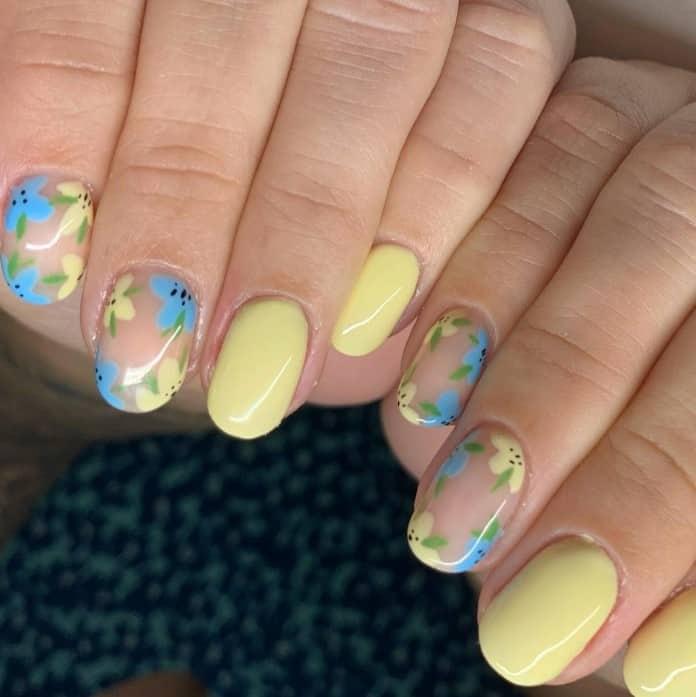 a woman's nails with sweet summer florals in pale blue and yellow