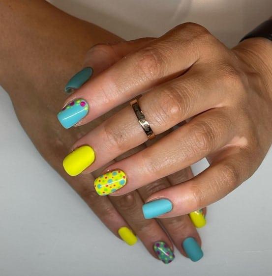 a woman with blue and yellow nails a nice punch with multicolored polka dots on select nails