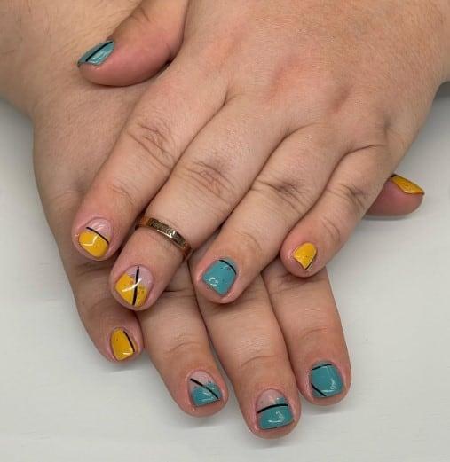 a woman's short nails with deep turquoise and yellow polish and classy geometric lines