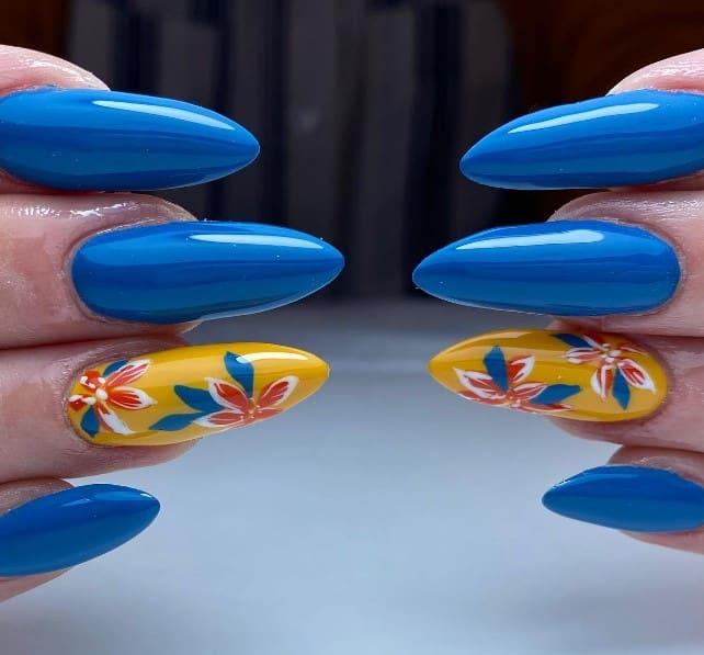 a sharp sculpted nails with a fun tropical touch with a yellow accent nail with blue and orange hibiscus flowers
