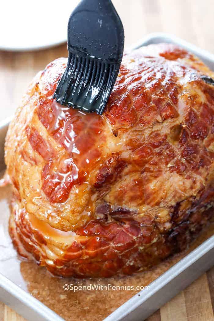 Baked Ham with Brown Sugar Glaze being brushed with glaze
