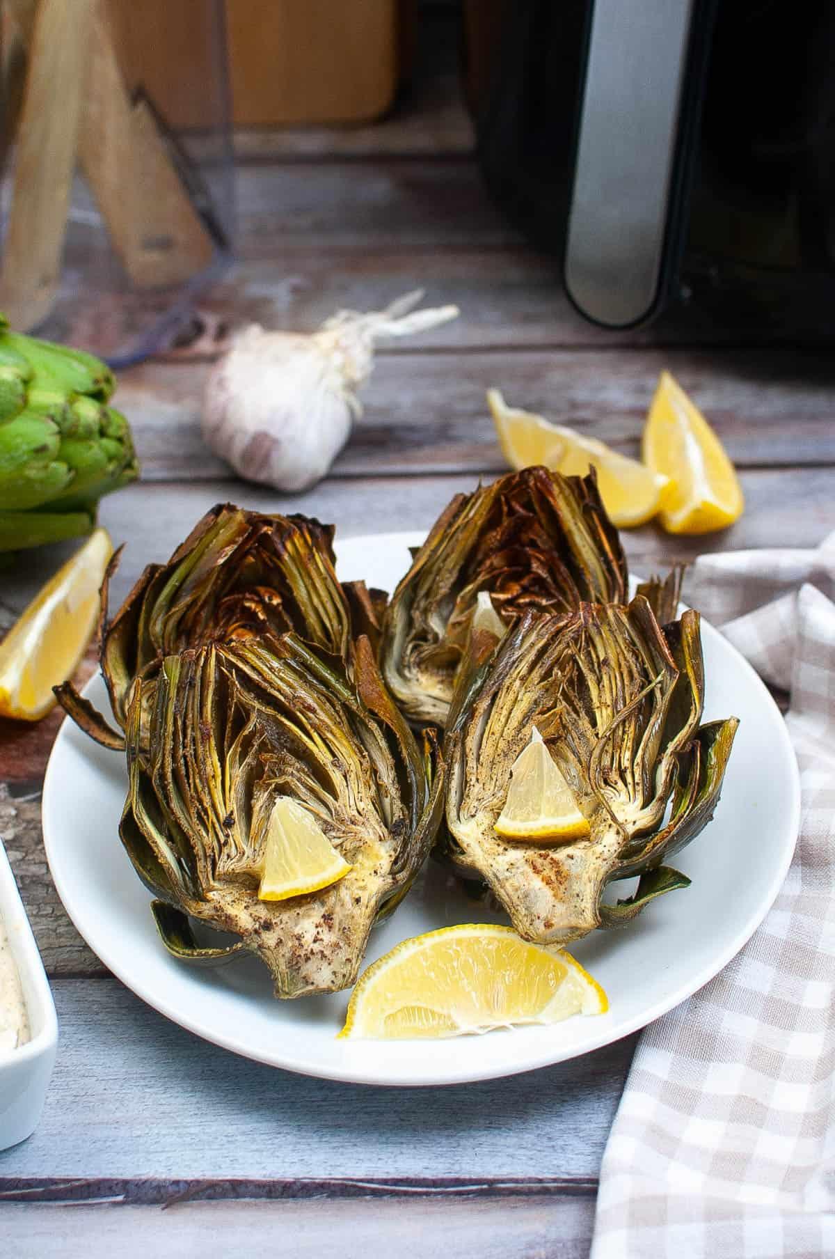 Low angle shot of air fryer artichokes on a plate.