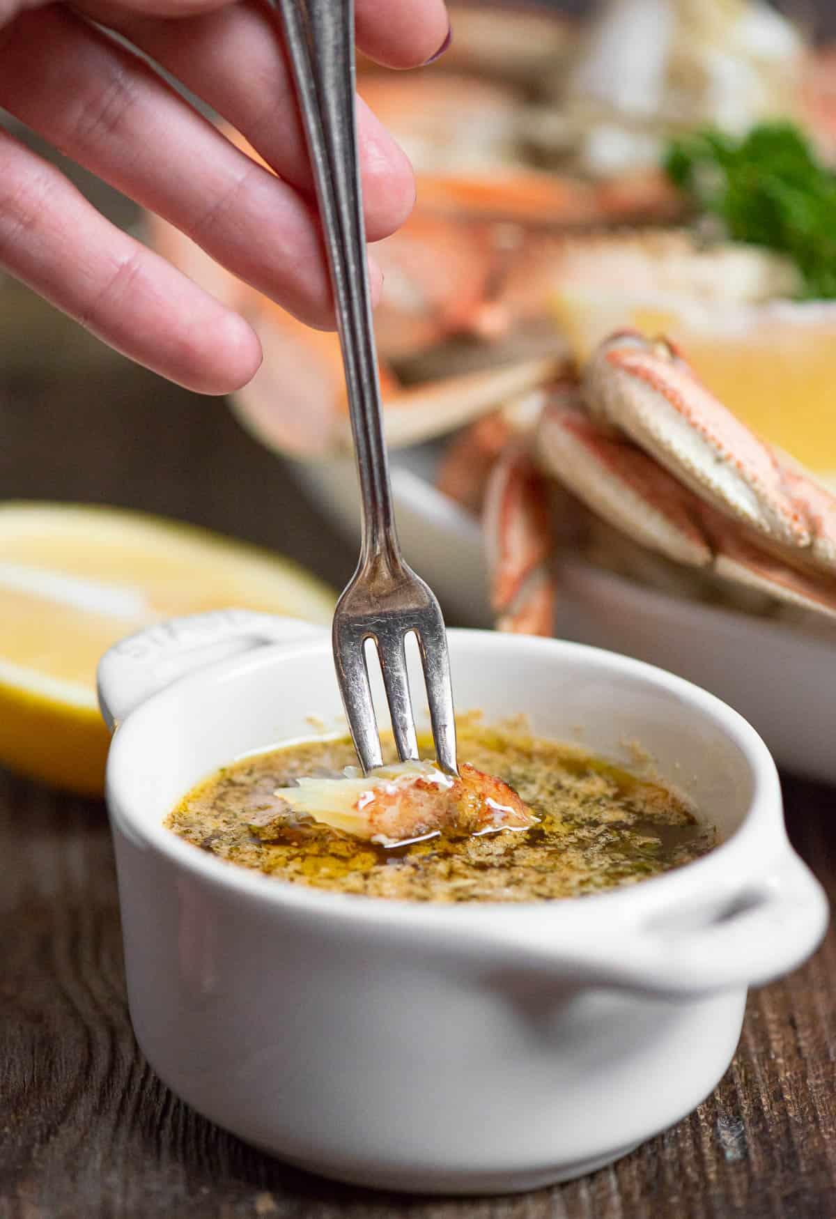 dipping crab meat into garlic butter.