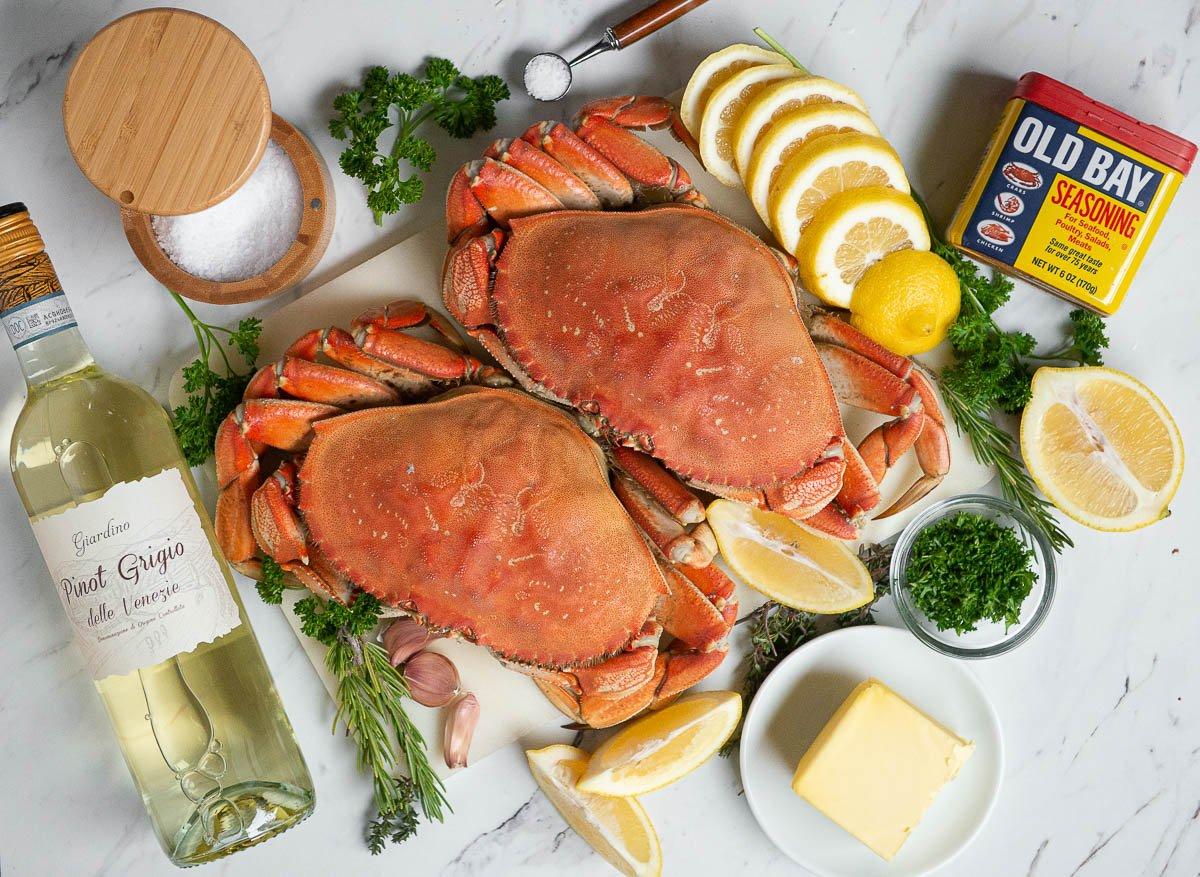 Dungeness crab legs with aromatics and garlic butter ingredients.