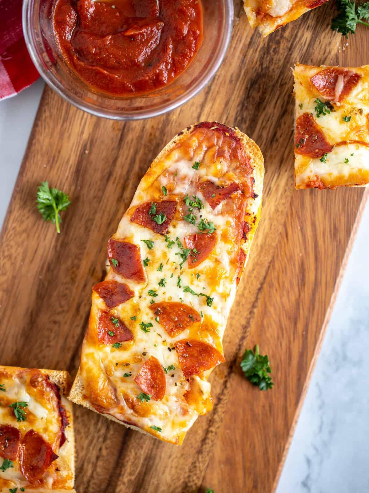Air Fryer French Bread Pizza with Pepperoni on cutting board after being cooked.
