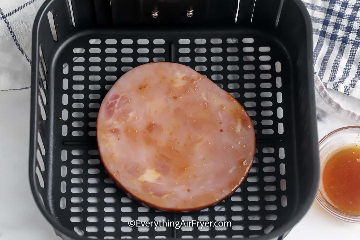 Ham Steak topped with a glaze in an air fryer basket