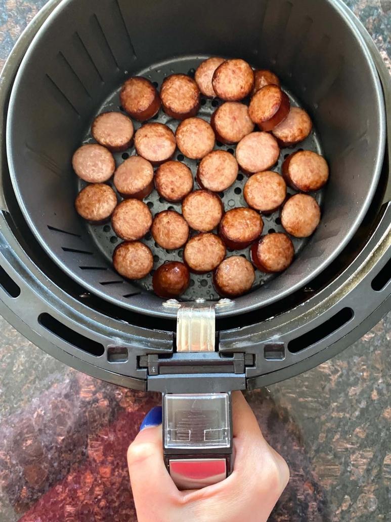 air fryer basket with cooked kielbasa slices