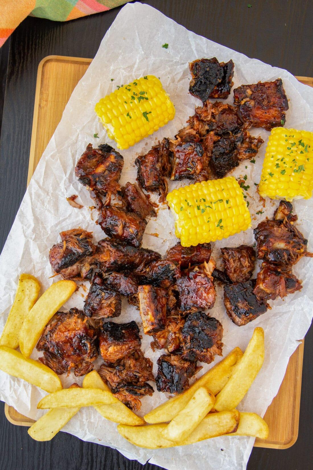 Rib Tips with fries and corn on cutting board