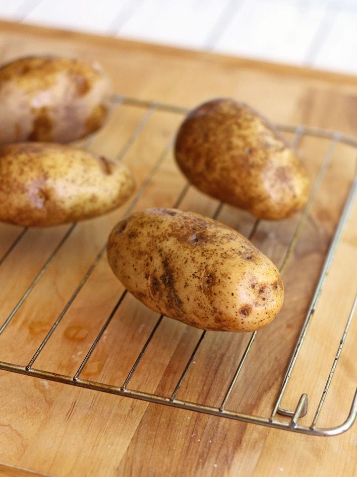Oil-rubbed potatoes on a cooking rack.