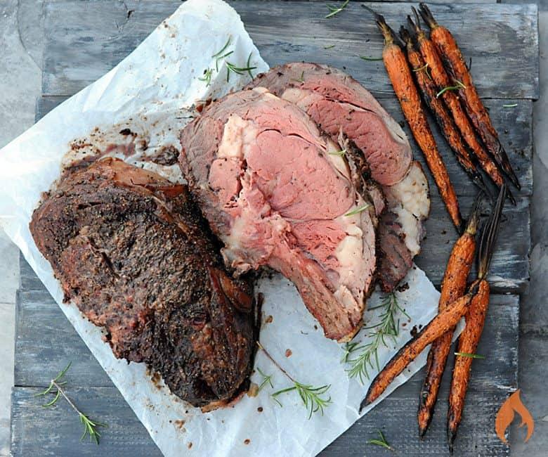 prime rib on grill over pan of vegetables