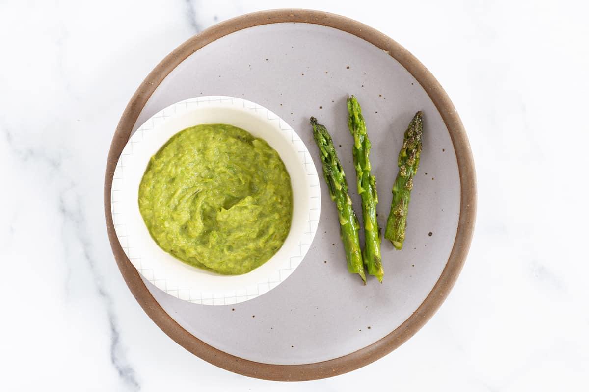 Cooked asparagus stalk heads on grey plate for baby-led weaning