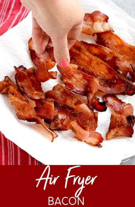 Air fryer bacon with hand grabbing a piece