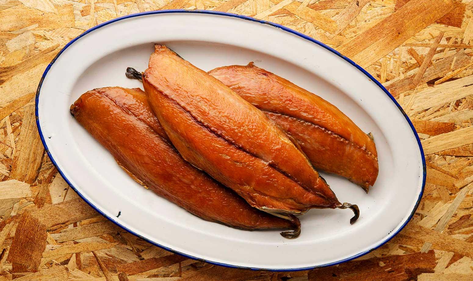 Three fillets of smoked bonito fish on a platter.