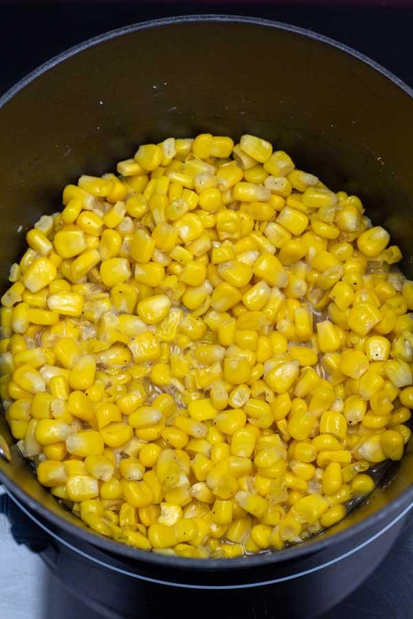 Process image 2 showing corn in a saucepan with seasoning and melted butter.