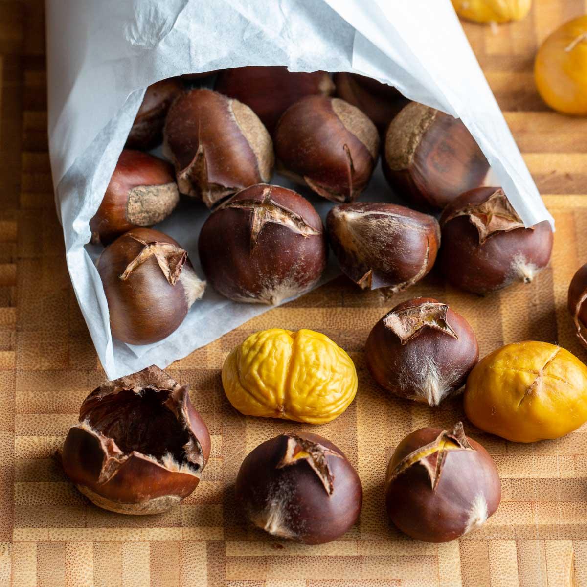 Roasted chestnuts falling out of a paper bag