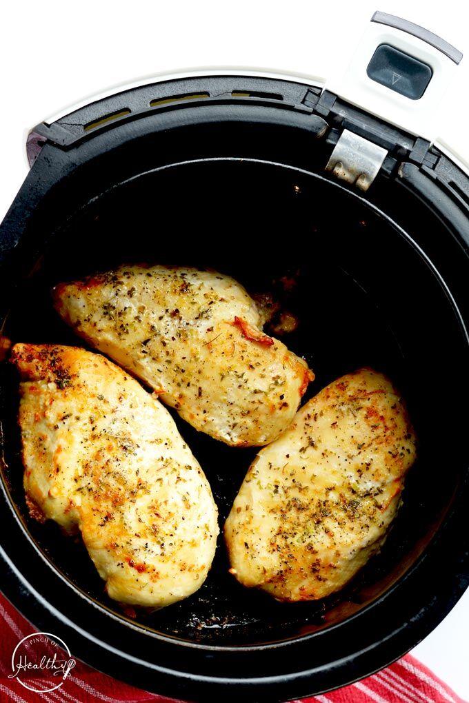 Air fryer chicken breast in cooking basket from overhead