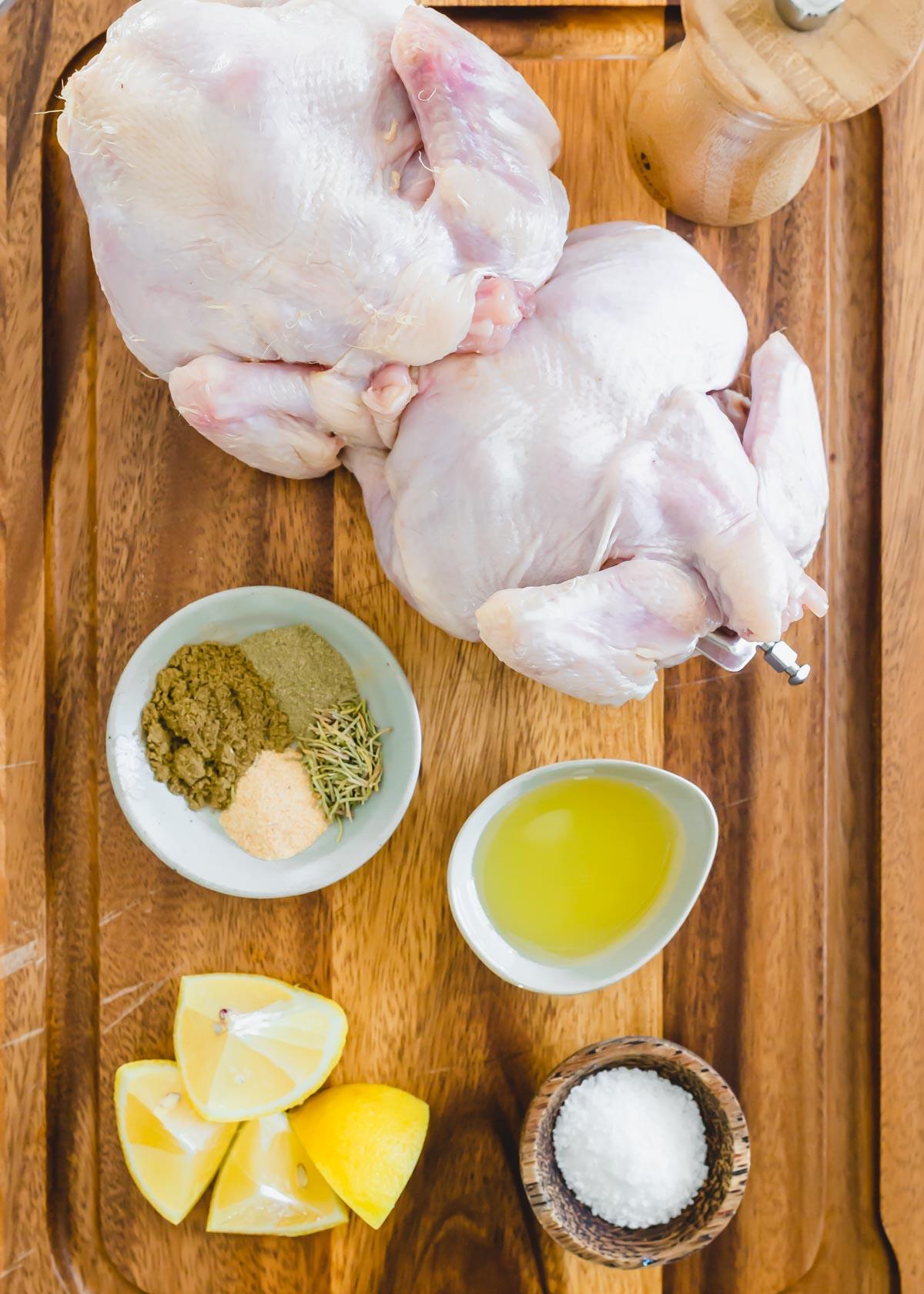 Ingredients to roast Cornish hens in the air fryer on a wooden cutting board.