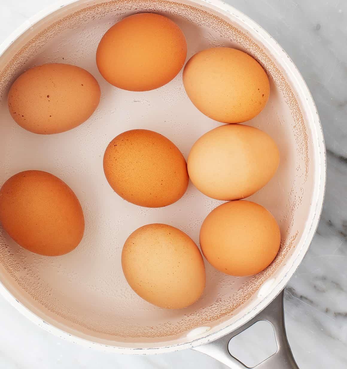 Eggs covered with 1 inch of water in a pot