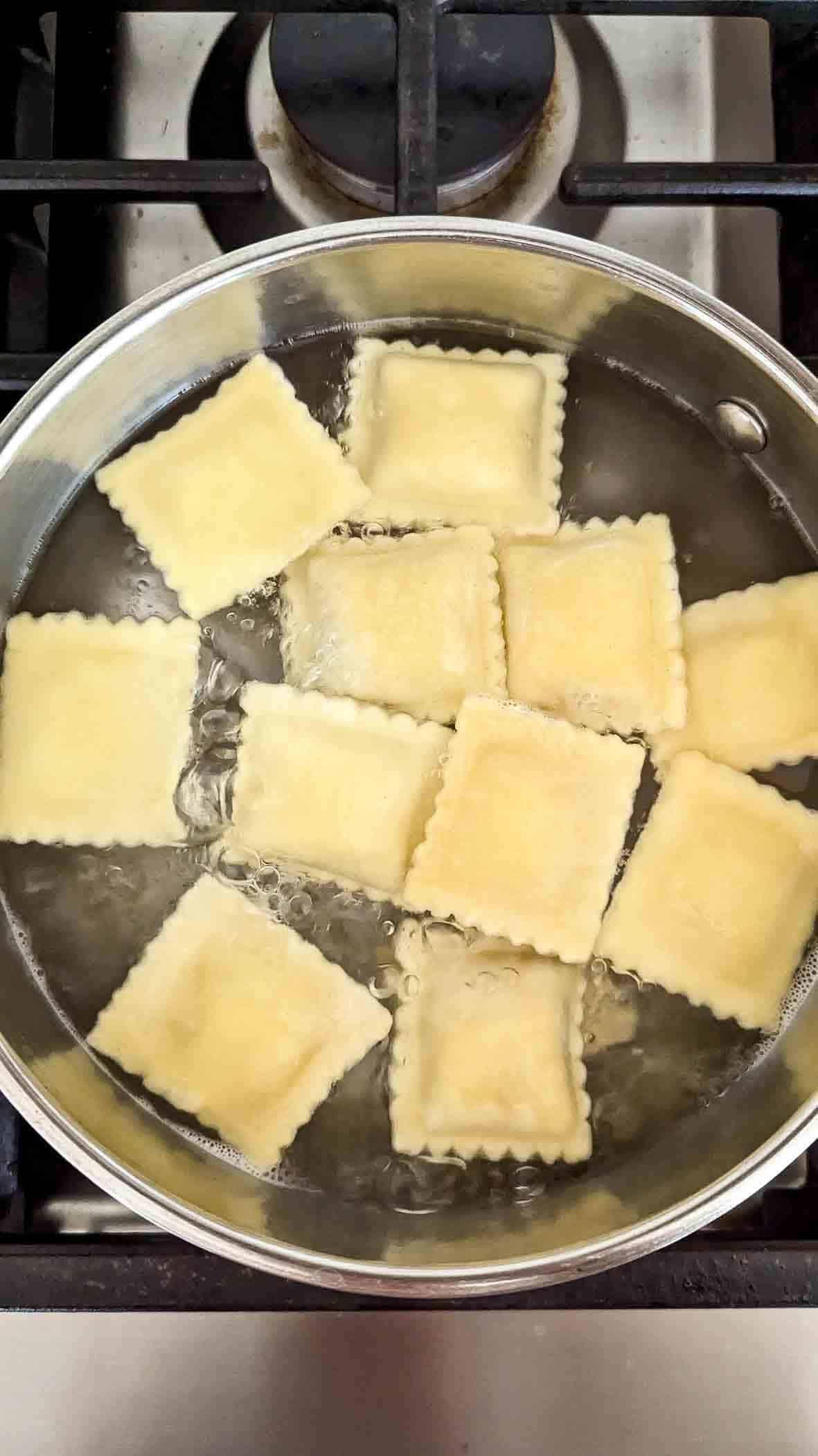cooked ravioli floating to the top of the pot of boiling water.