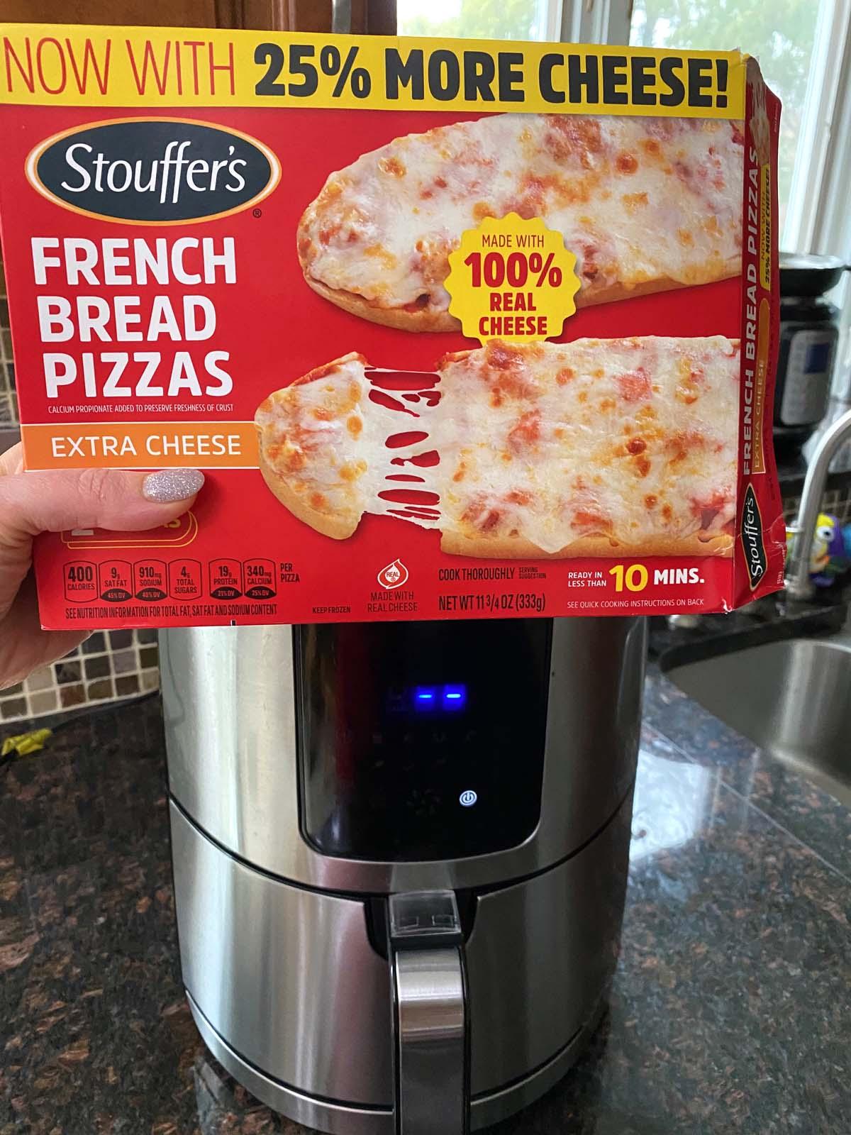 Box of French bread pizza in front of an air fryer.