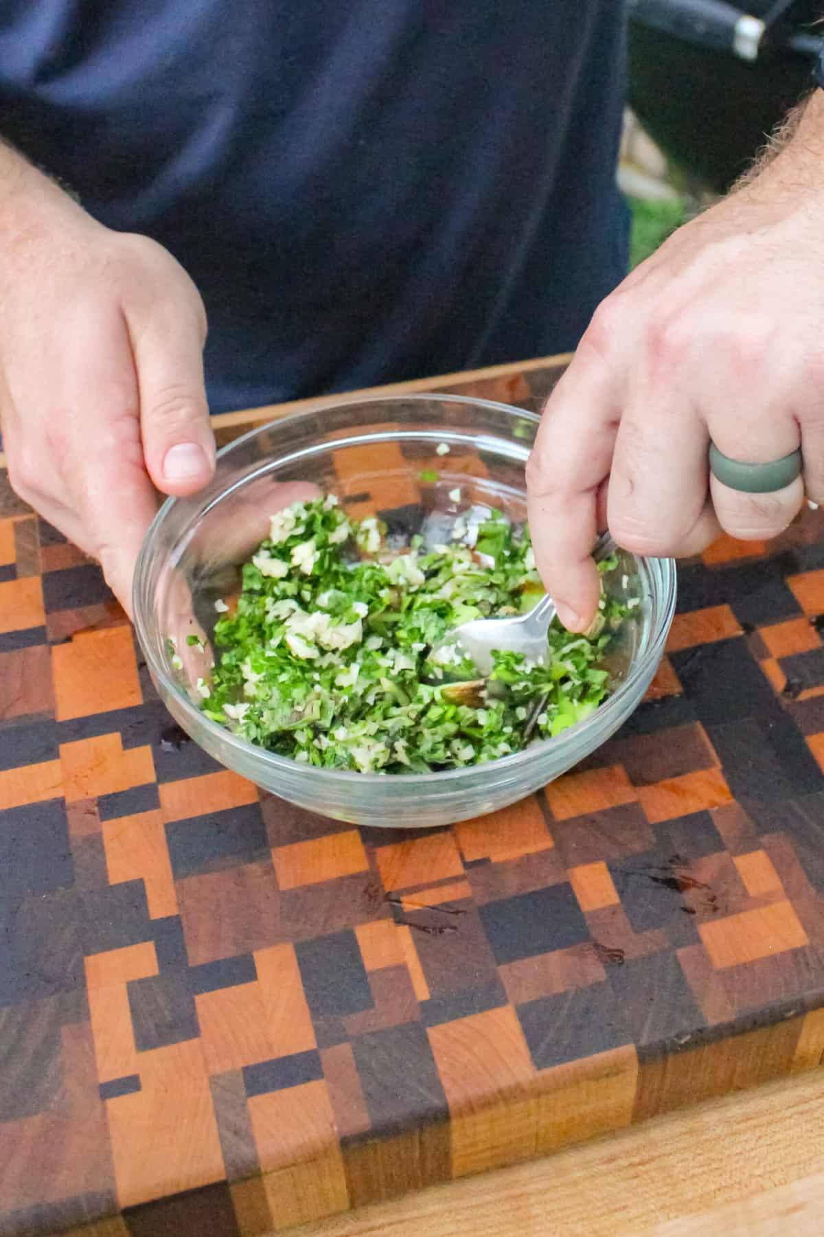 overhead of charred scallion gremolata being mixed in a small bowl