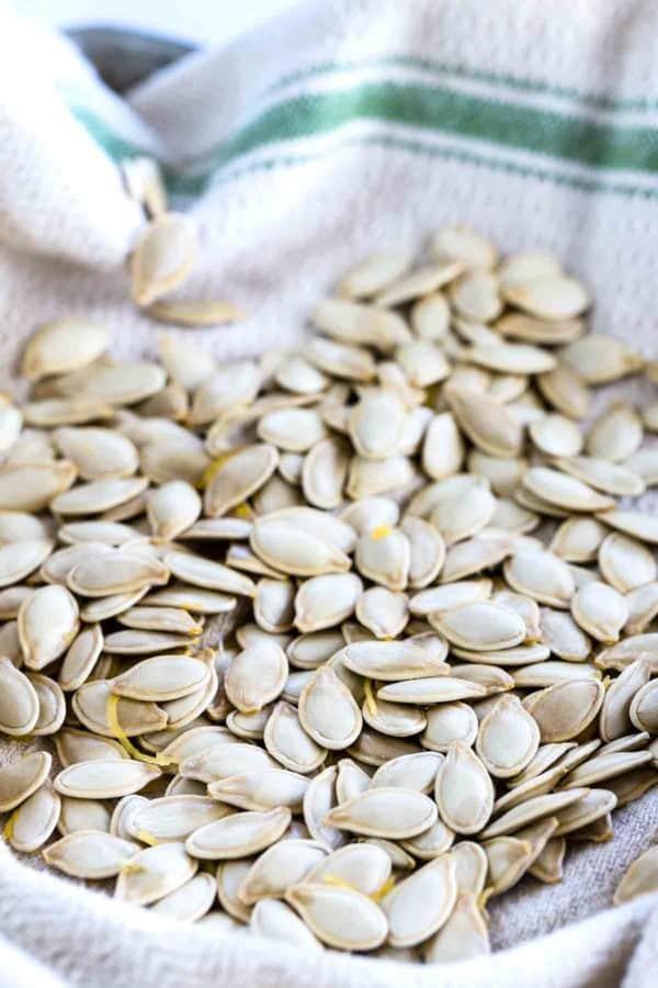 Drying a bunch of pumpkin seeds in a white towel