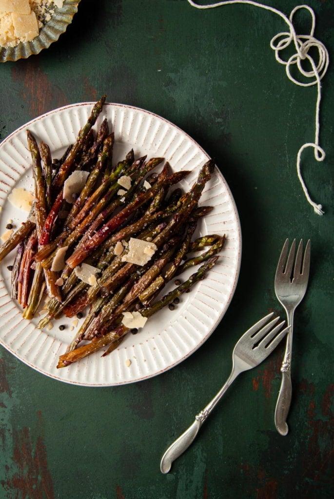 platter of purple asparagus with two forks