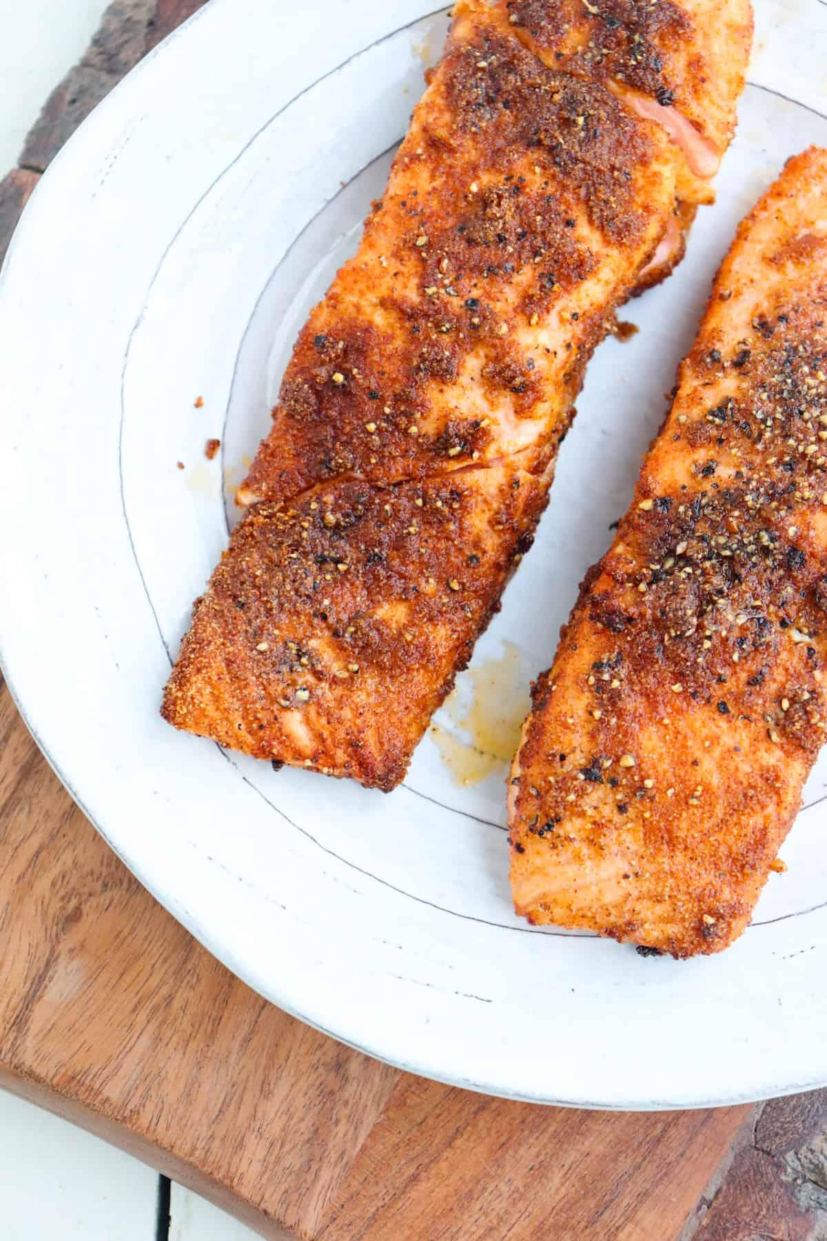 salmon that has been cooked in the air fryer resting on a white plate.