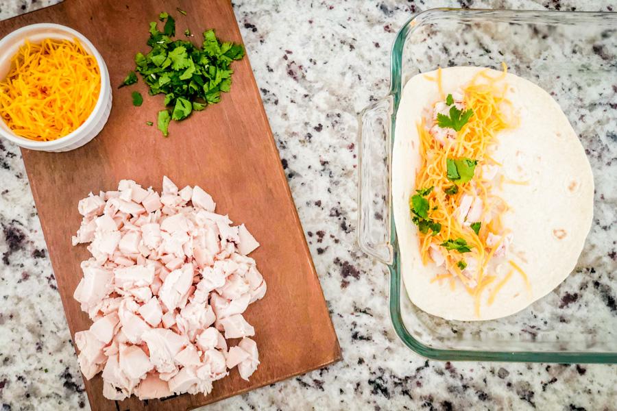 Diced chicken, cilantro, and cheese on a cutting board