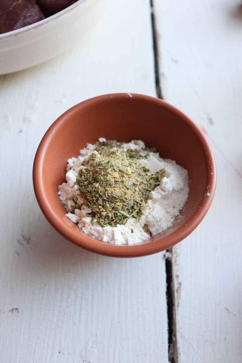 flour, salt, and Italian seasoning in a small orange bowl