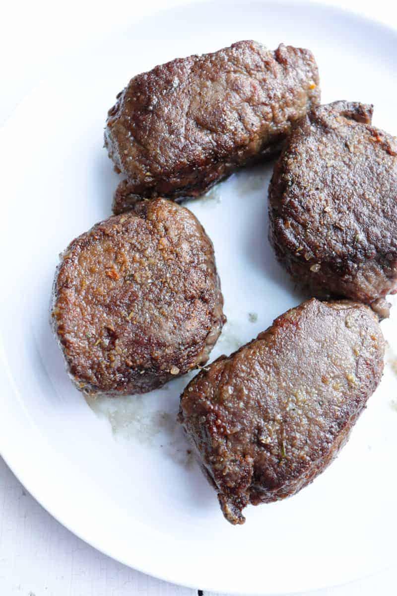 browned venison medallions on a white plate