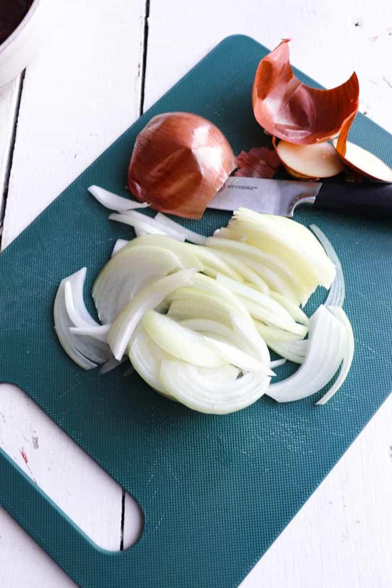 sliced onions on a green cutting board