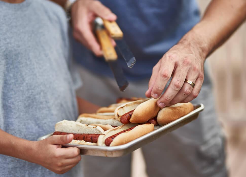father and son grilling hot dogs