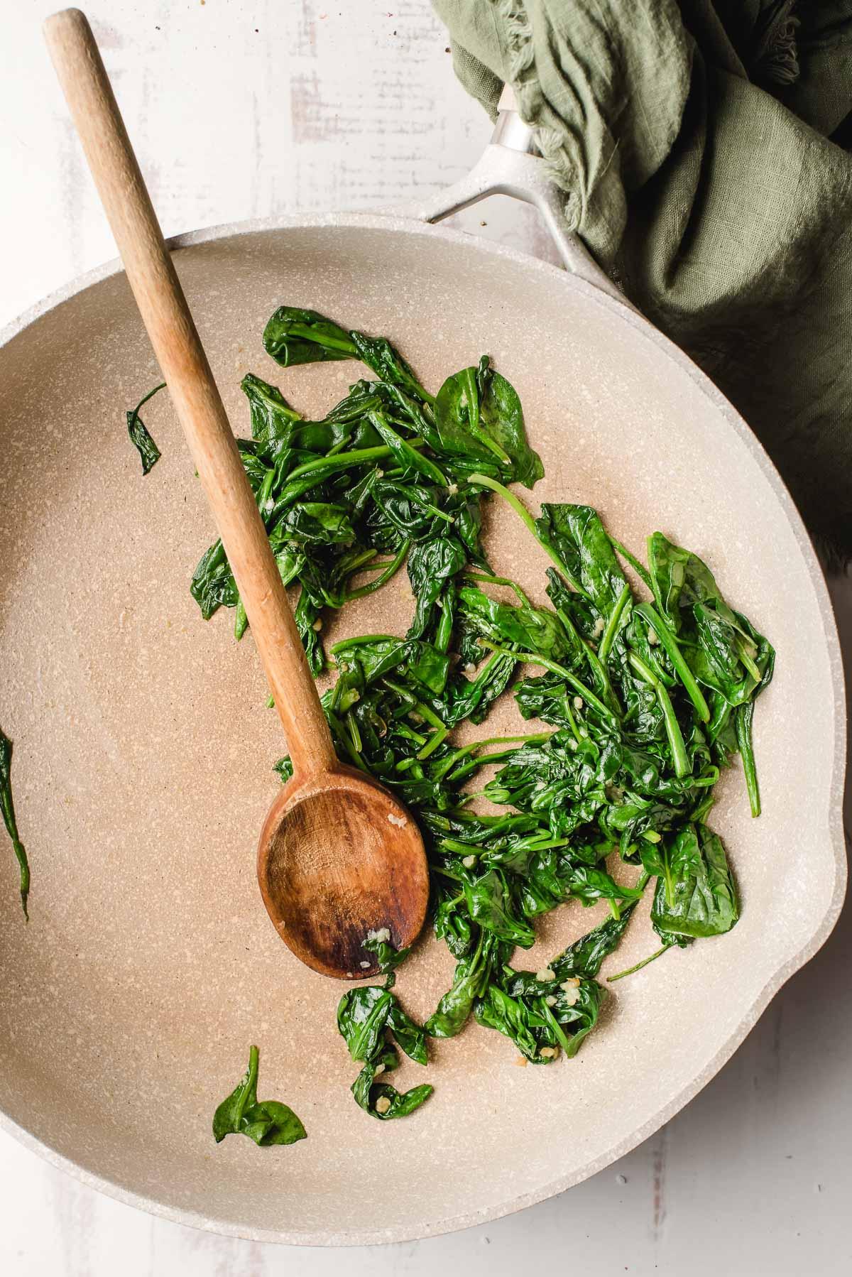 Garlicky sauteed spinach in a pan.