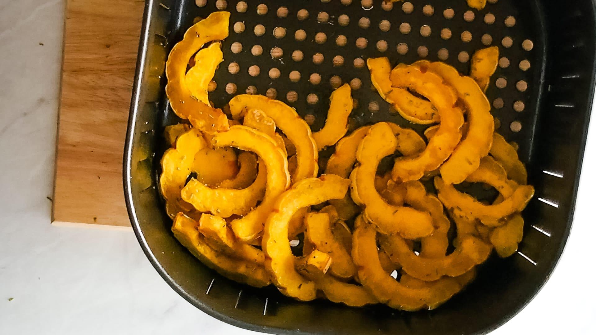 Air fryer delicata squash is a quick and easy side dish, perfectly seasonal for autumn. With the air fryer you can have roasted delicata squash on the table in about 15 minutes. There is no peeling necessary! These tasty crescent moon shaped squash rings make a fun finger food too, that you can eat as a healthy alternative to fries. #wintersquash #airfryer #delicata
