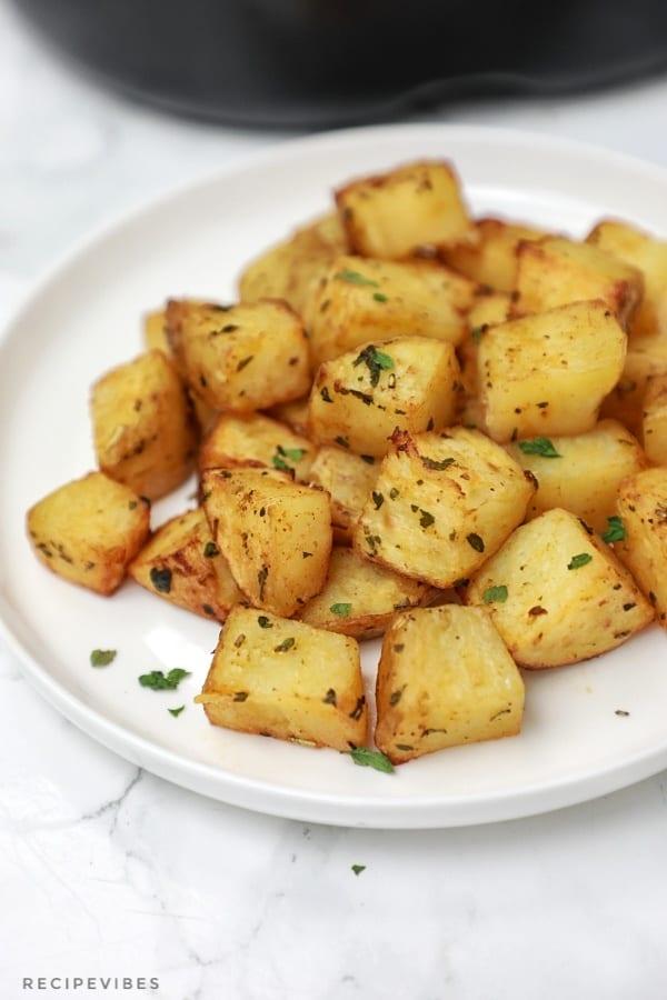 Diced Air fryer potatoes served on a white plate.