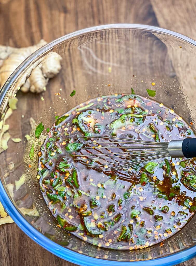 beef marinade in a glass bowl with a whisk
