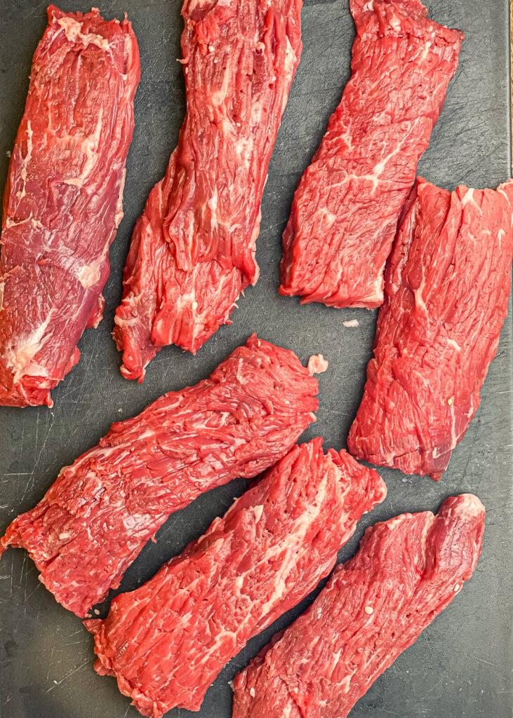 seven pieces of flap meat on a cutting board