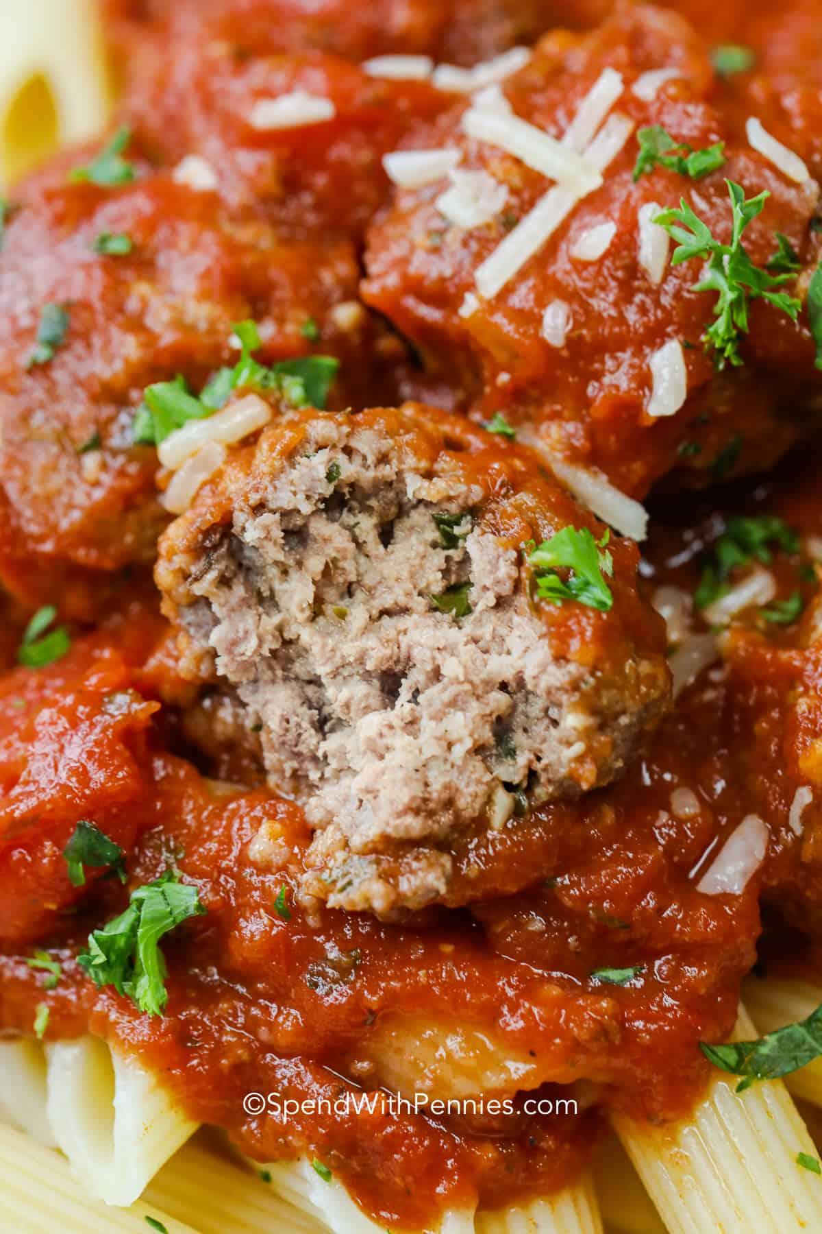 close photo of the inside of a crockpot meatball with tomato sauce