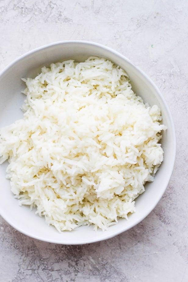 Top-down shot of white rice in a white bowl on a table