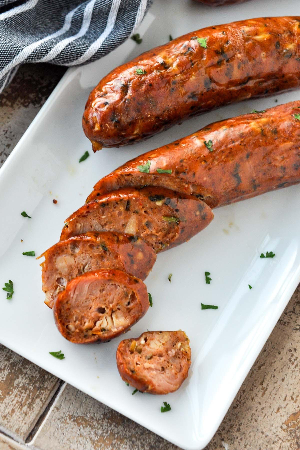 Chicken sausages on a plate with sausage slices.