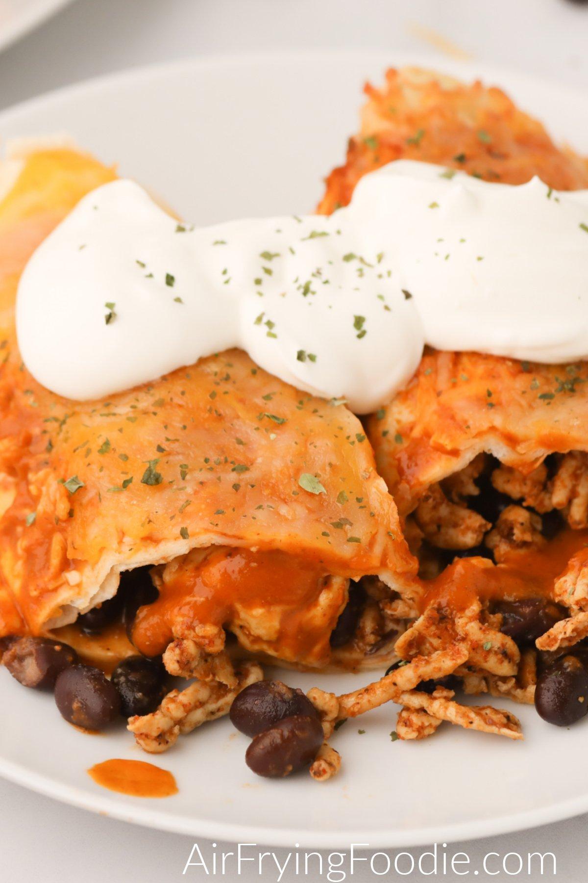 Homemade air fryer enchiladas served on a white plate and ready to eat.