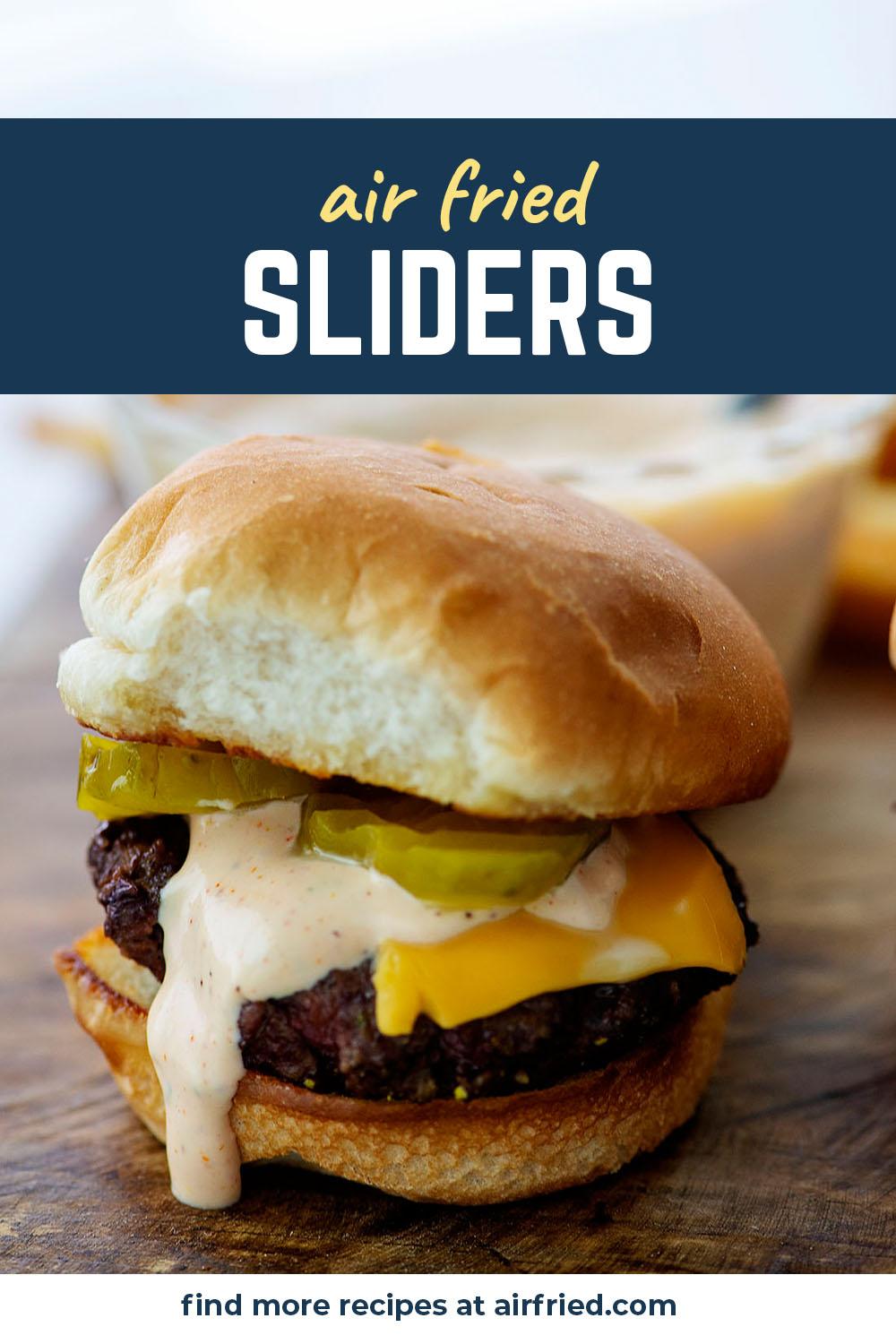 Slider with sauce, cheese, and pickles on it.