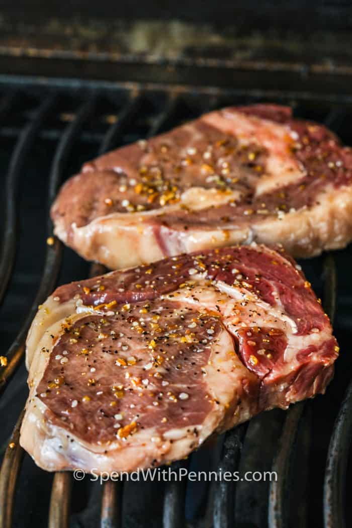 2 steaks on a grill to show How to Cook a Perfect Ribeye Steak