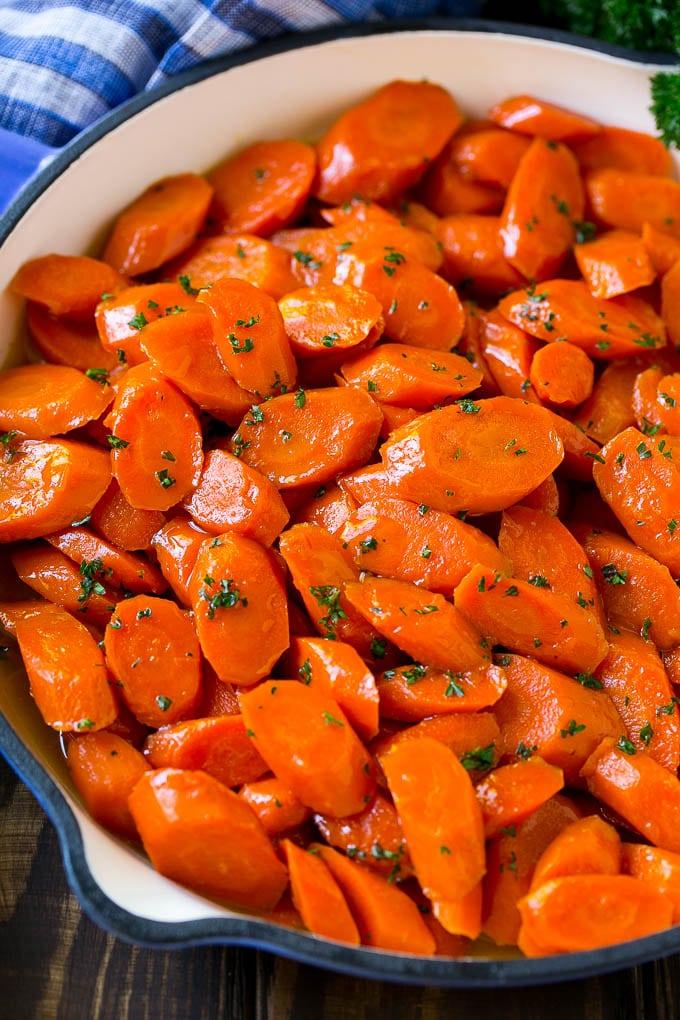 A skillet of glazed carrots with brown sugar and butter sauce.