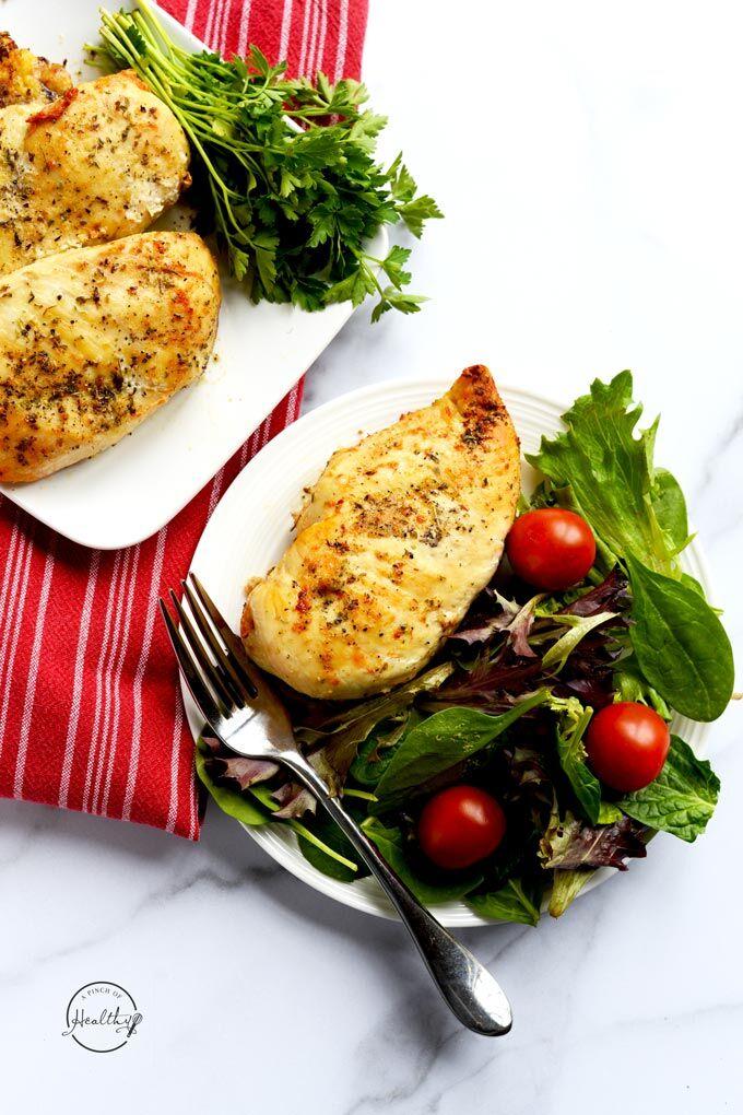 Air fryer chicken breast on a white plate with a salad