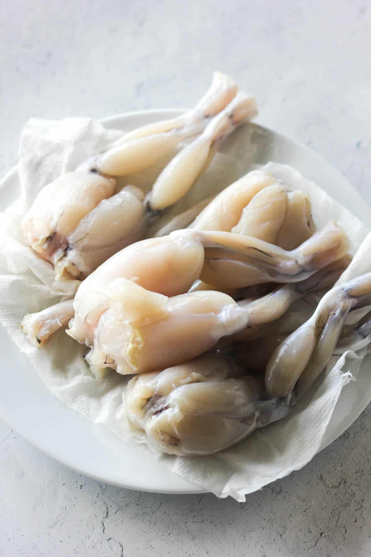 raw frog legs on the plate