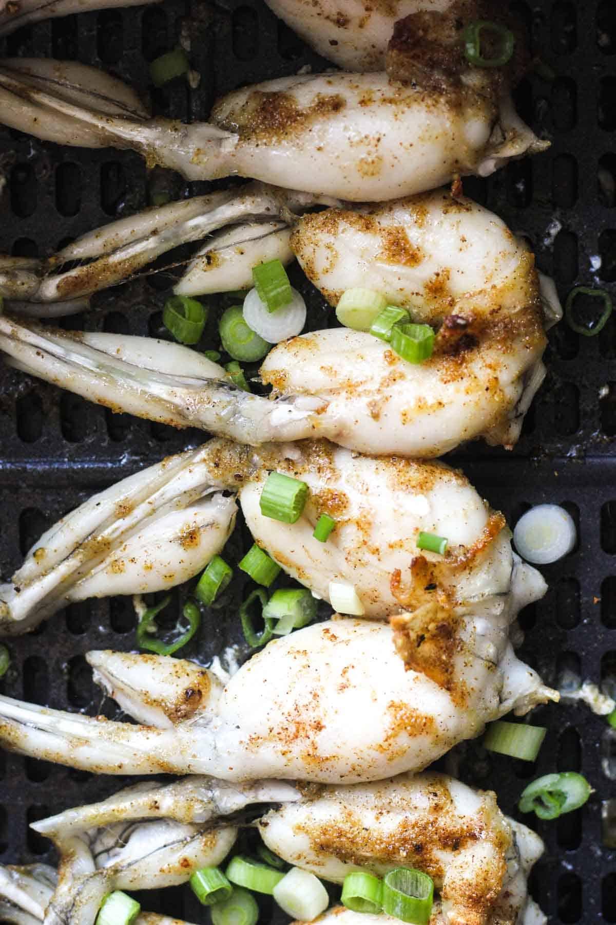 cooked frog legs in the air fryer with chopped green onions