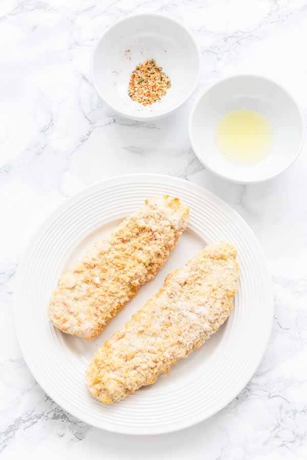 Frozen breaded fish fillets in oven on a white plate