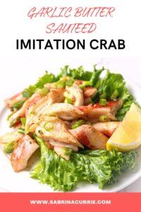 White plate topped with green lettuce and sautéed pink and white seafood mixture with a lemon wedge on one side and a fork on the other.